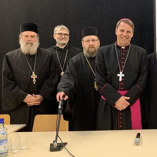 V.l.: Archimandrit Nicodim Petre, Abt Marianus, Weihbischof Sofian von Kronstadt, Bischof Stefan Oster, Metropolit Serafim Joanta, Metropolit Teofan Savu, Bischof Macarie Dragoi
roDK2023